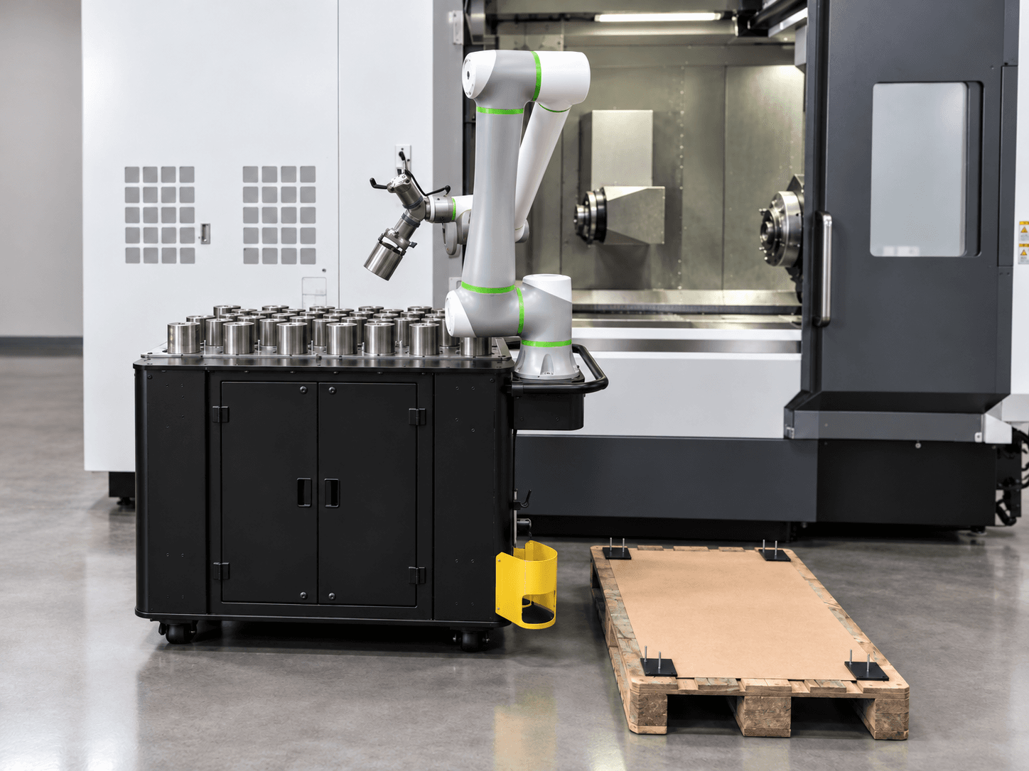 Mobile Anton robot station in front of a CNC machine with a parts tray and pallet